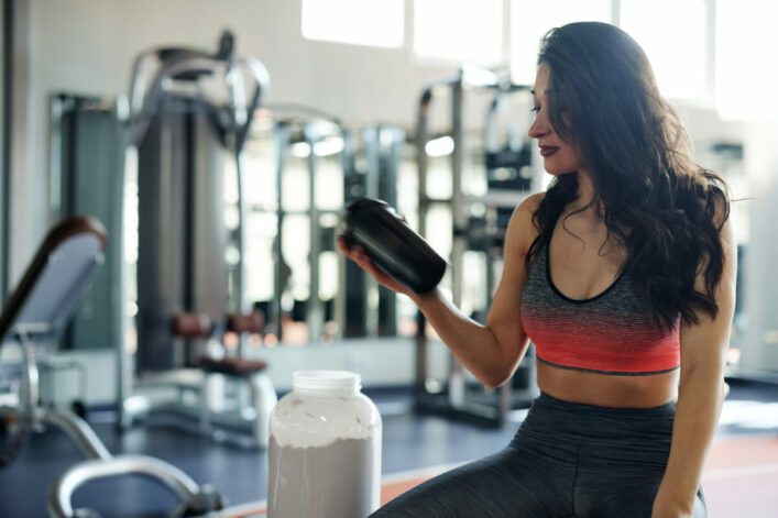 une femme avec shaker de protéine nutrition sportive
