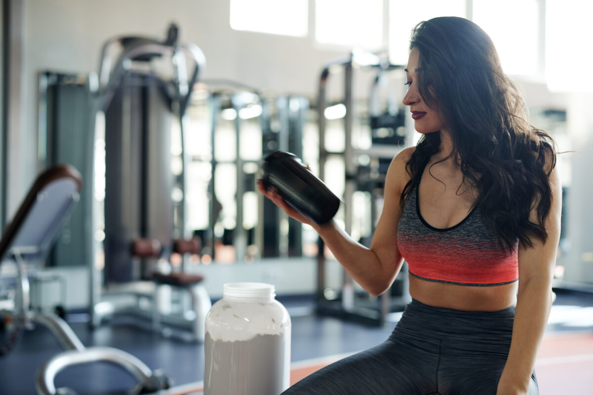une femme avec shaker de protéine nutrition sportive