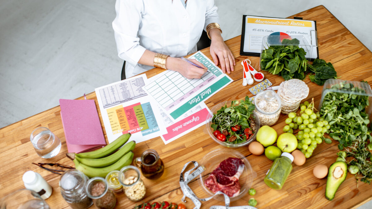 un diététicien apprenant le lien entre stress et alimentation avec des légumes et des fiches pratiques